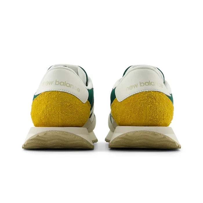 New Balance 237 V1 sneakers back view featuring white leather panels, yellow suede heel detail, and green accents.