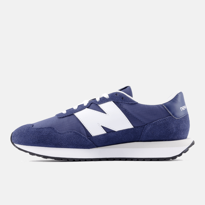 New Balance 237 sneakers in navy with white suede and nylon upper, large side "N" logo, and cushioned midsole, side view.