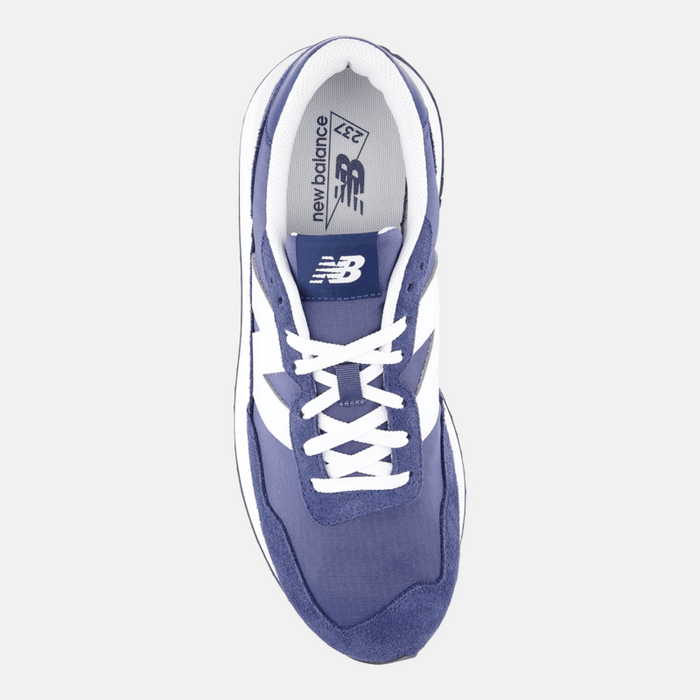 New Balance 237 sneakers in blue with white accents, suede and mesh upper, white laces, and New Balance logo on tongue, top view.