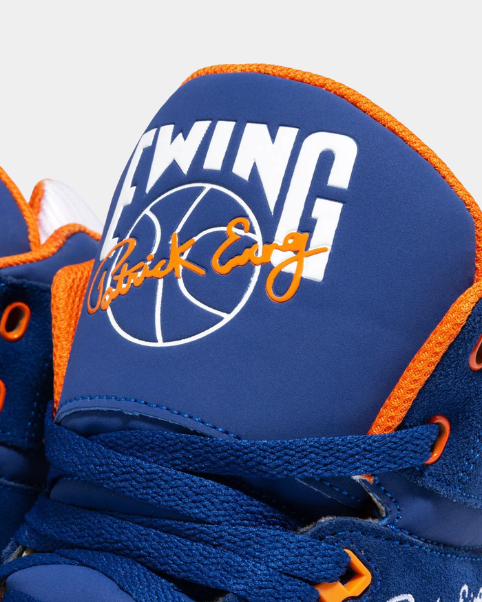 Ewing Athletics 33 HI OG sneakers in royal blue and orange with embroidered Patrick Ewing signature and basketball logo, close-up of tongue detailing.