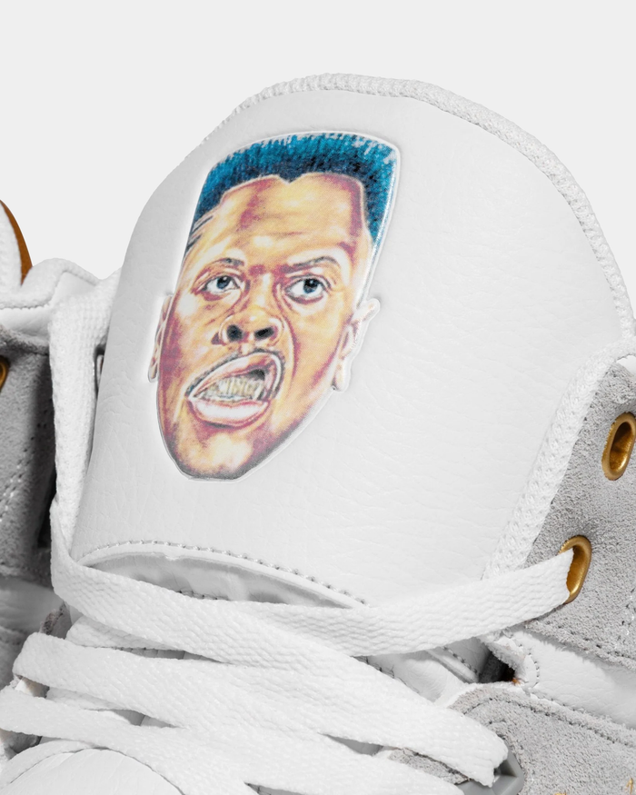 Ewing Athletics 33 HI x Laurens J sneakers, close-up of white leather tongue with embroidered graphic detail, white laces, and suede gray overlays.