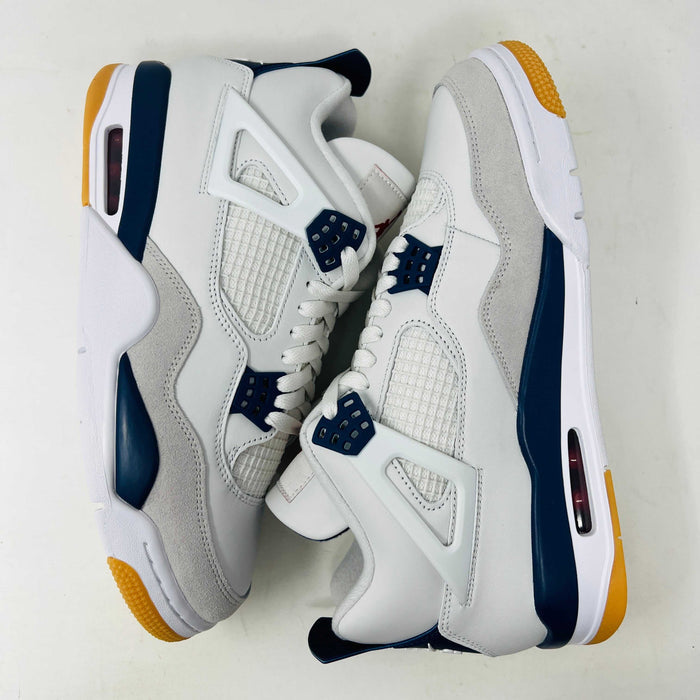 The Jordan 4 Retro SB Navy from Holy Ground Sneaker Shop, with white and navy mesh and orange details, sits on a pristine box showcasing the Nike SB logo. Its cushioned heel ensures its a perfect accessory addition.