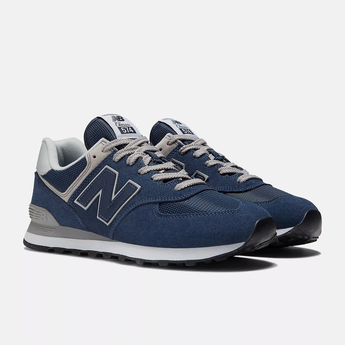 New Balance 574 Core sneakers in navy suede and mesh with gray accents and lace-up closure, angled front view.