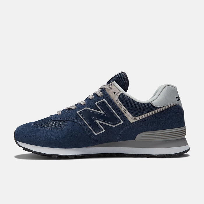 New Balance 574 Core sneakers in navy blue suede and mesh with gray accents, side view highlighting "N" logo and cushioned midsole.