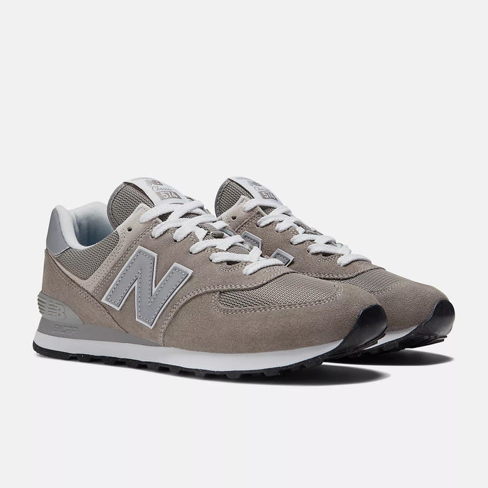 New Balance 574 Core sneakers in taupe gray with suede and mesh upper, white laces, and EVA midsole, angled front view.