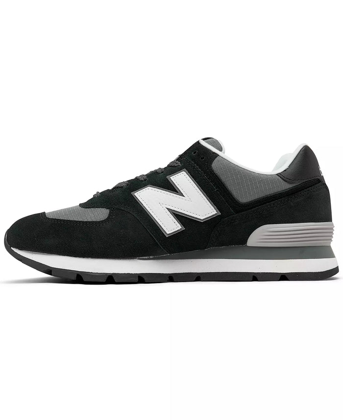 New Balance 574 Rugged sneakers in black and gray suede with ripstop accents and white midsole, side view.