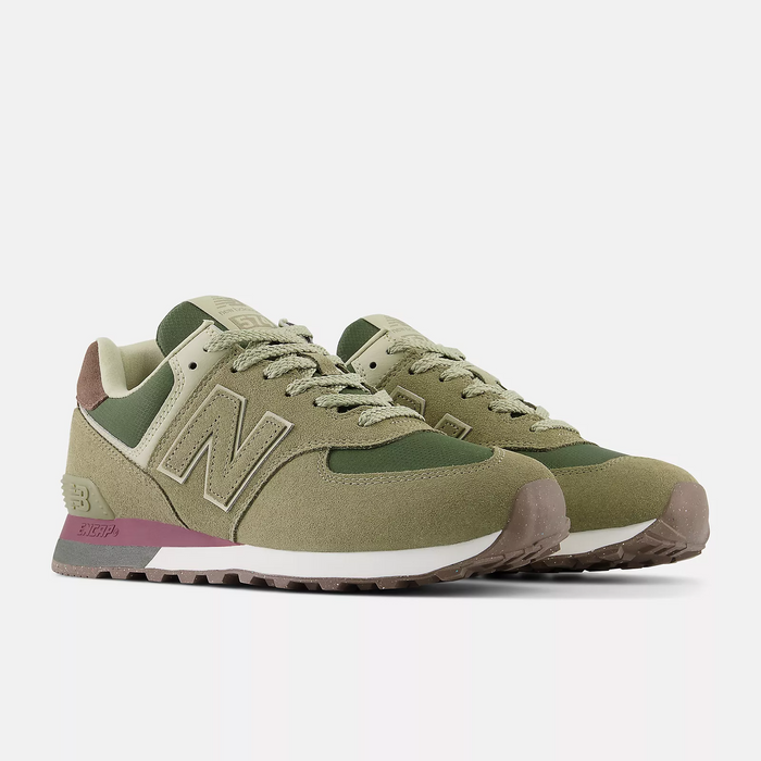 New Balance 574 sneakers in olive green with suede and mesh upper, brown heel detail, and speckled rubber outsole, angled front view.