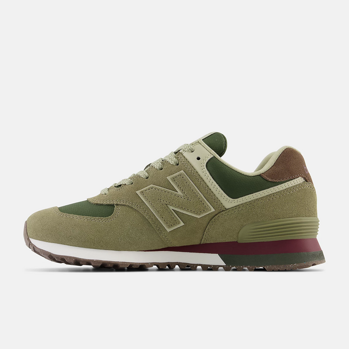 New Balance 574 sneakers in olive green suede with mesh panels, brown and maroon accents, and a rubber outsole, side view.