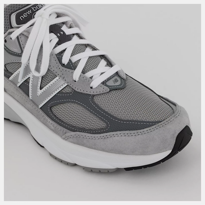 New Balance 990v6 running shoes in gray with mesh upper, suede overlays, white laces, and cushioned midsole, angled front view.