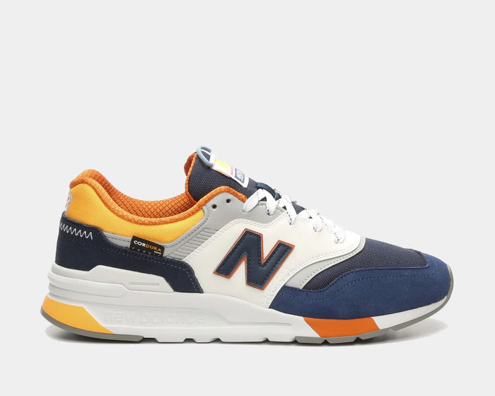 New Balance 997H sneakers in navy, white, and orange with Cordura fabric and suede overlays, side view.