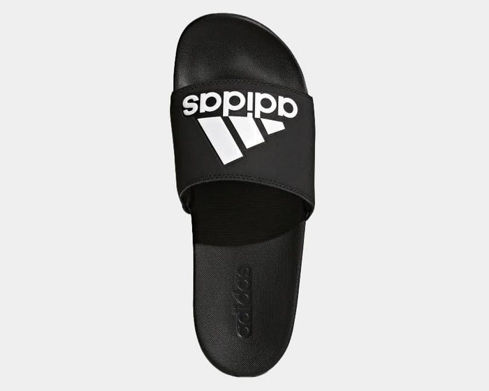 Adidas Adilette Comfort Slides in black with white logo on strap and textured footbed, top view.
