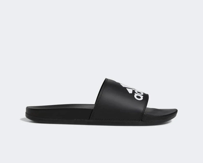 Adidas Adilette Comfort slides in black with white logo on synthetic strap and cushioned sole, side view.