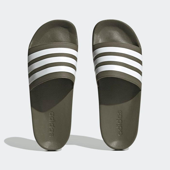 Adidas Adilette Comfort slides in olive green with white three-stripe detail and cushioned footbed, top view.