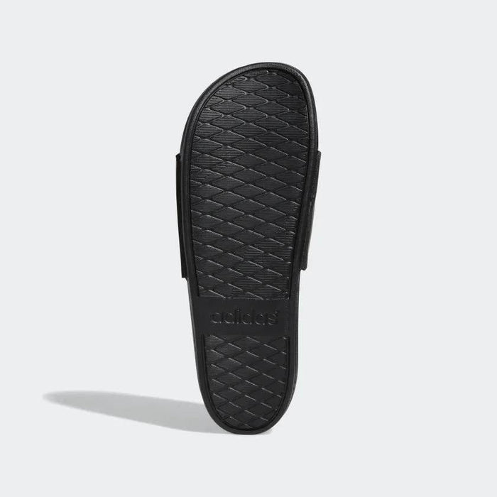 Adidas Adilette Comfort slides outsole in black with textured diamond pattern and embossed logo, sole/bottom view.