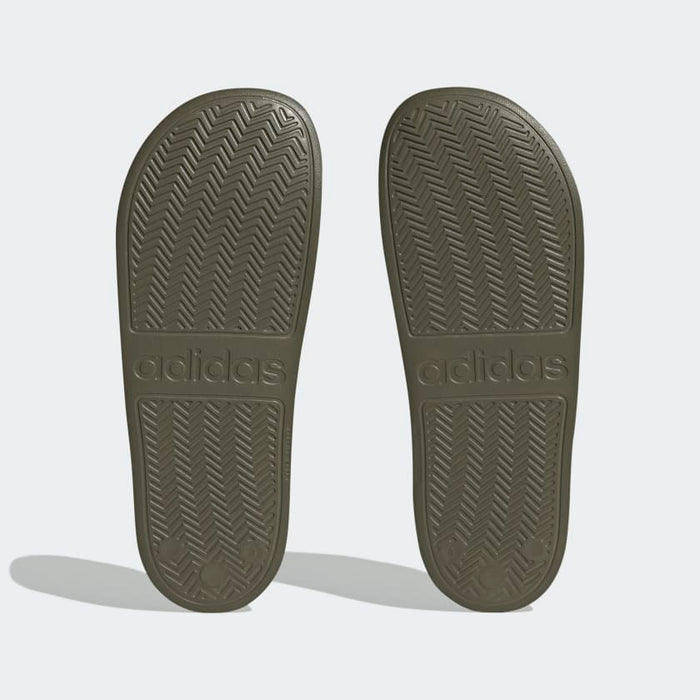 Adidas Adilette Comfort slides outsole in olive green with herringbone grip pattern and embossed Adidas logo, bottom view.