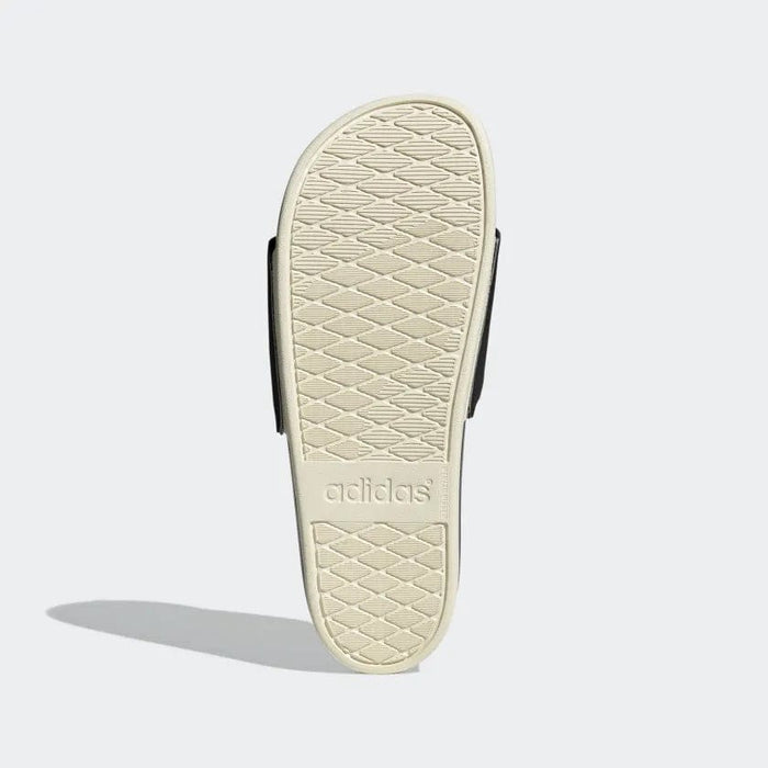 Adidas Adilette Comfort sandals sole view showing beige textured outsole with Adidas branding.