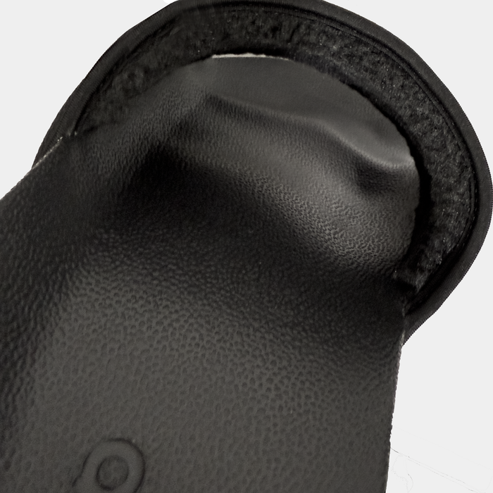 Adidas Adilette NoShower slides in black, close-up view showing textured footbed and soft padded strap detail.
