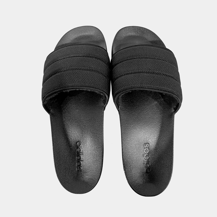 Adidas Adilette NoShower slides in solid black with textured strap and embossed logo, top view.
