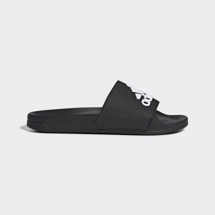 Adidas Adilette Shower Slides in black with a white logo and synthetic strap, side view