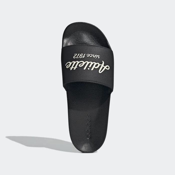 Adidas Adilette Shower Slides black with bold "Adilette since 1972" text on strap, top view.