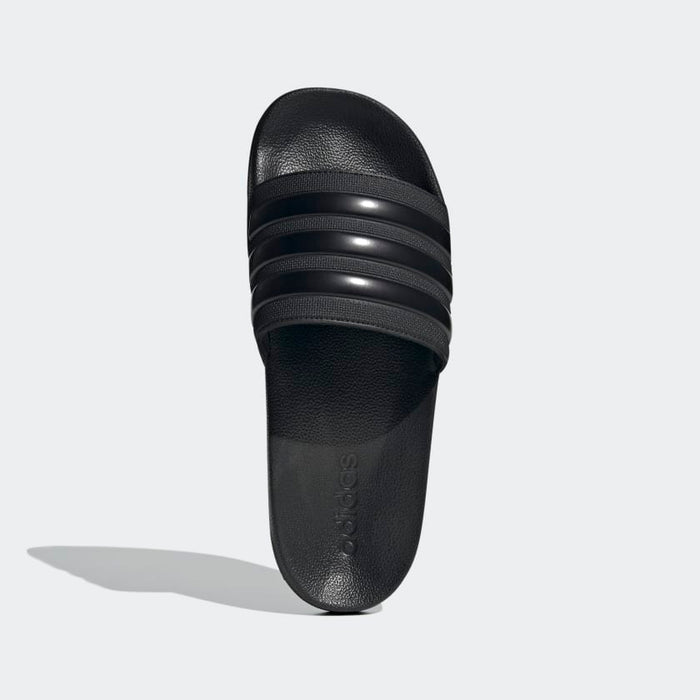 Adidas Adilette Shower Slides in black with textured footbed and three-stripe design, top view.