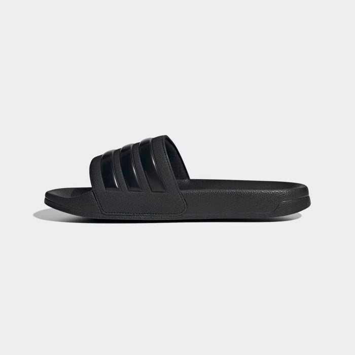 Adidas Adilette Shower Slides in black with three-stripe design and textured sole, side view.