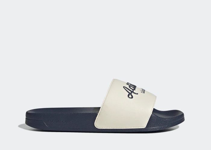 Adidas Adilette Shower Slides in navy blue and white with soft Cloudfoam footbed and logo-printed strap, side view.