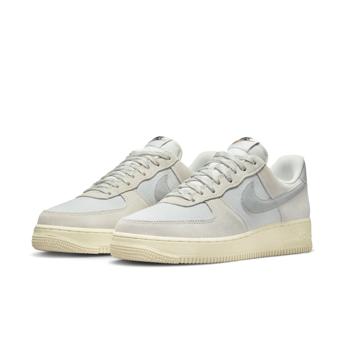 Nike Air Force 1 '07 LV8 sneakers featuring off-white suede overlays, white mesh upper, light gray leather Swoosh, and cream-colored rubber sole, front angle view.