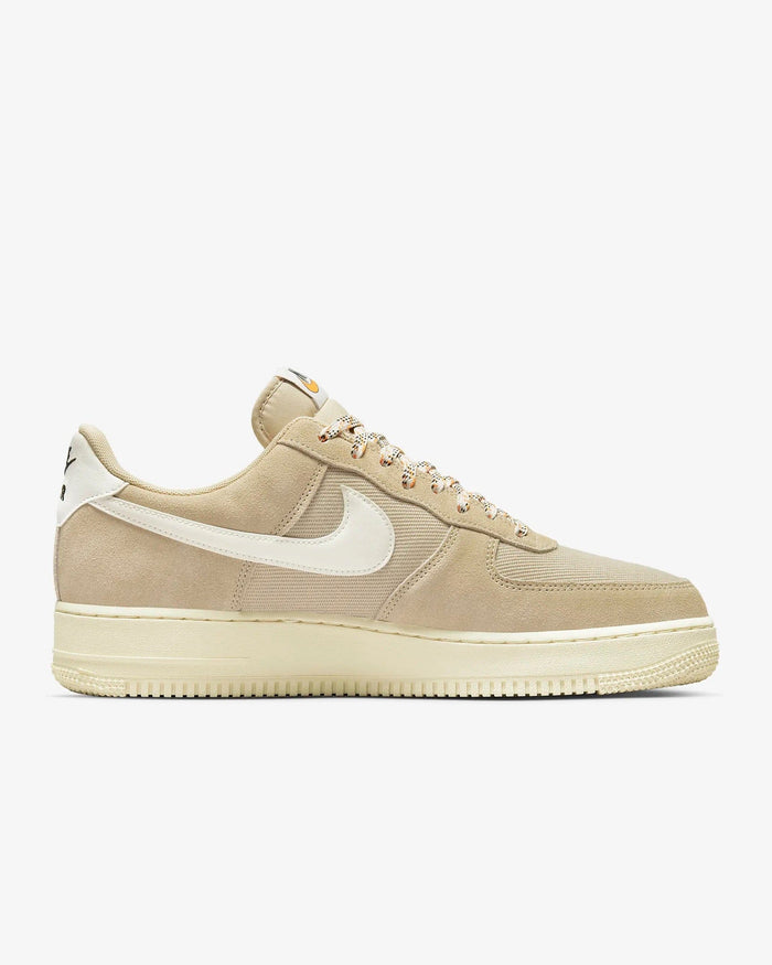 Nike Air Force 1 '07 LV8 sneakers in beige suede with white leather Swoosh and tonal mesh panels, side view.