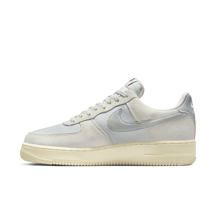 Nike Air Force 1 '07 LV8 sneakers in light gray with suede overlays, textured mesh panels, and cream-colored rubber sole, side view.