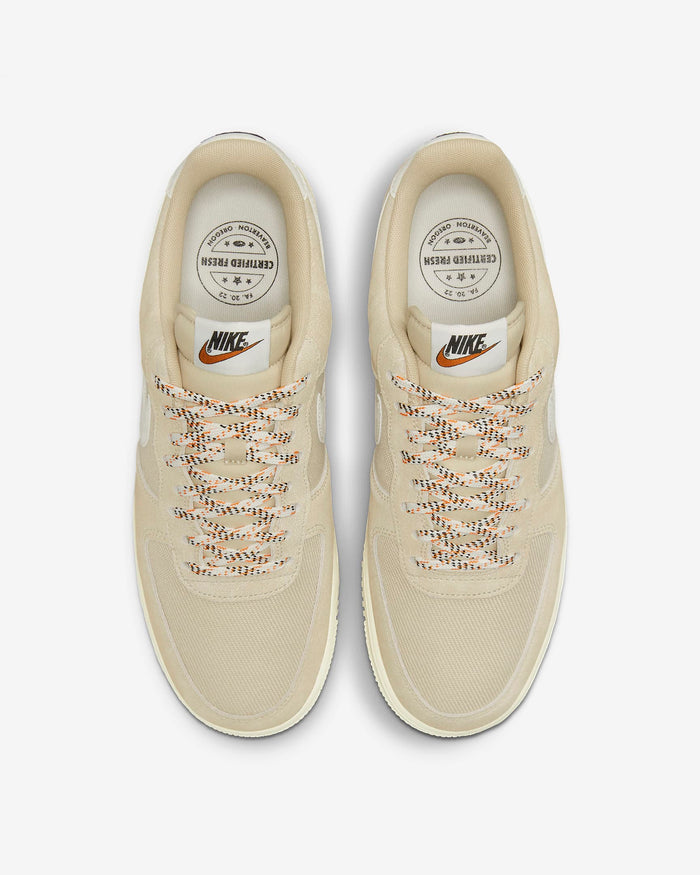 Nike Air Force 1 '07 LV8 sneakers in beige with textured mesh upper, multicolored laces, and branded insoles, top view.