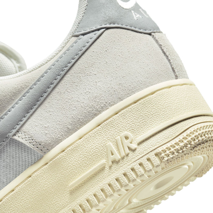 Nike Air Force 1 '07 LV8 sneakers in textured gray and off-white leather, close-up of heel and sole.