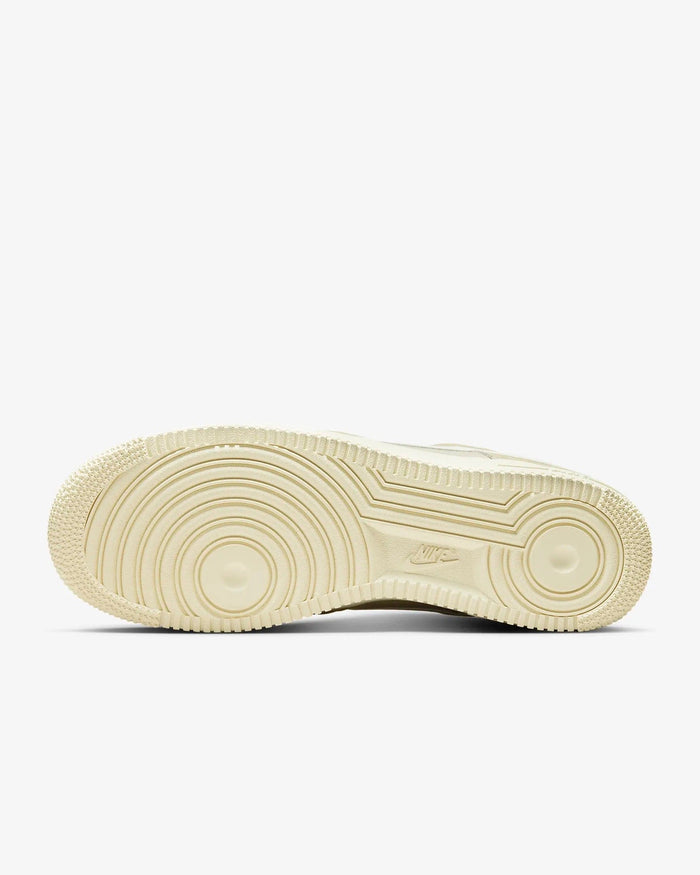 Nike Air Force 1 '07 LV8 shoes outsole in beige showing circular tread pattern and embossed Nike logo, bottom view.