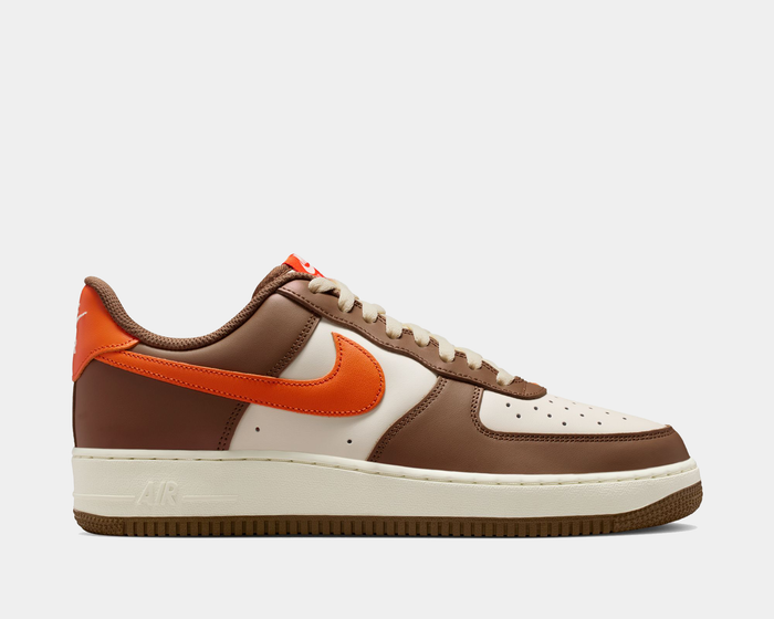 Nike Air Force 1 '07 sneakers in brown, cream, and orange leather with perforated toe box and signature Swoosh logo, side view.