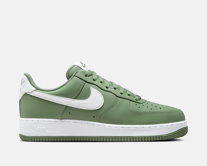Nike Air Force 1 '07 sneakers in green with white leather Swoosh, perforated toe box, and rubber outsole, side view.