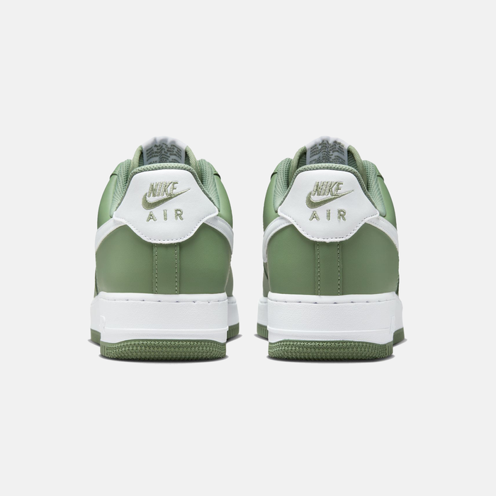 Nike Air Force 1 '07 sneakers in green with white heel tab featuring embroidered gold branding, back view.