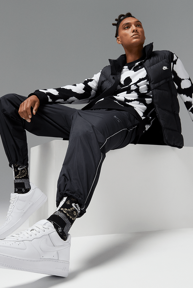 Nike Air Force 1 '07 sneakers in crisp white leather with perforated toe box and tonal stitching, lifestyle view worn with casual outfit.