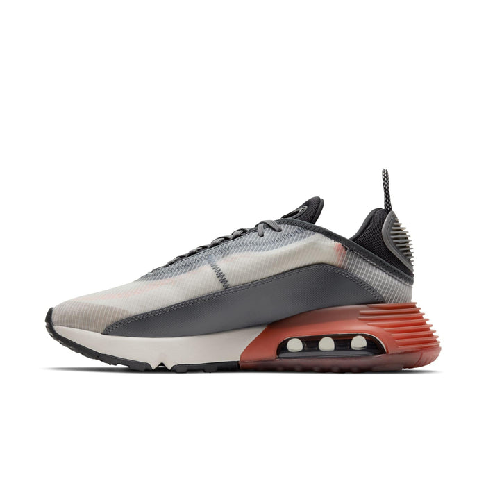 Nike Air Max 2090 sneakers in gray and translucent white, featuring a visible Air unit and textured orange heel, side view.