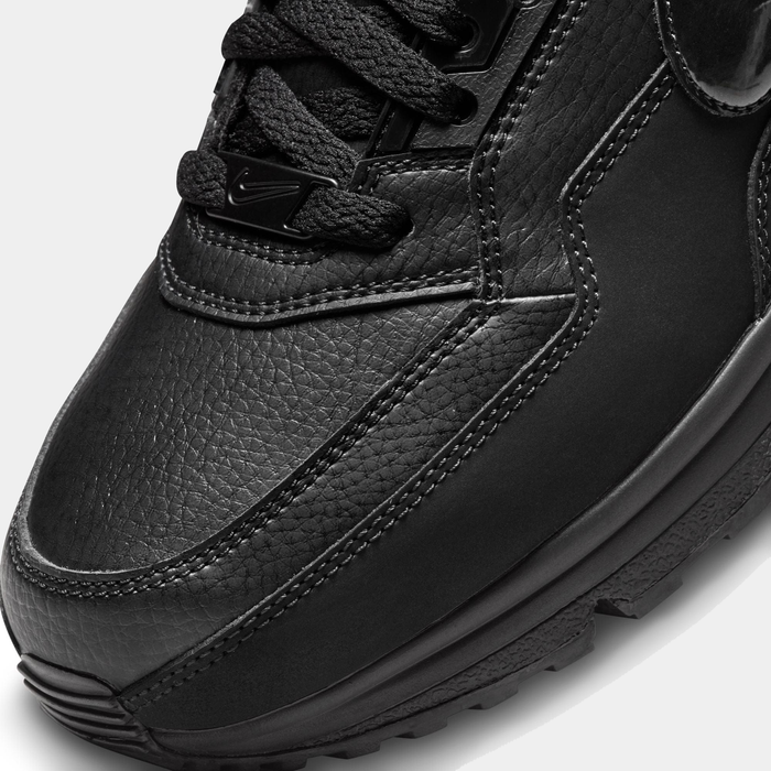 Close-up of a black leather sneaker on a light gray background
