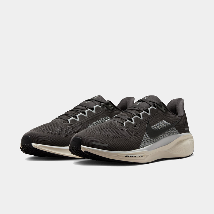 Pair of black running shoes with a white sole on a light gray background