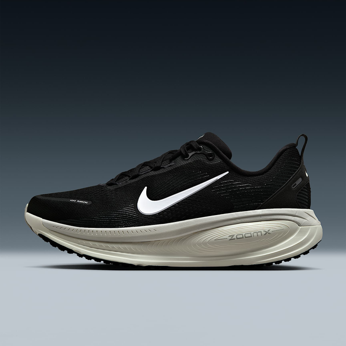 Nike Air Zoom Vomero 18 running shoe in black with white Swoosh logo and beige ZoomX foam midsole, side view.