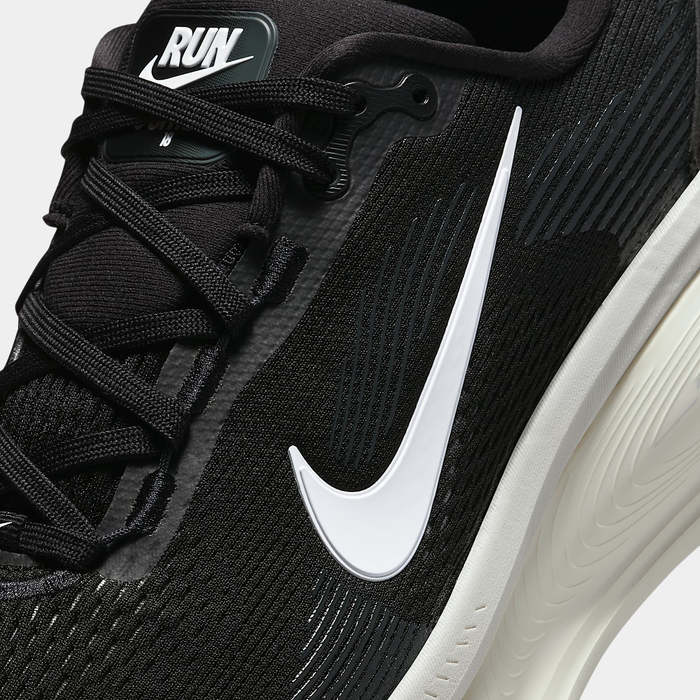 Nike Air Zoom Vomero 18 running shoes in black with white swoosh logo and textured mesh upper, close-up side view.