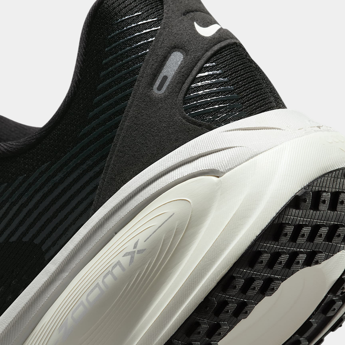 Nike Air Zoom Vomero 18 running shoes, close-up of black mesh upper with striped detailing and white ZoomX foam midsole.