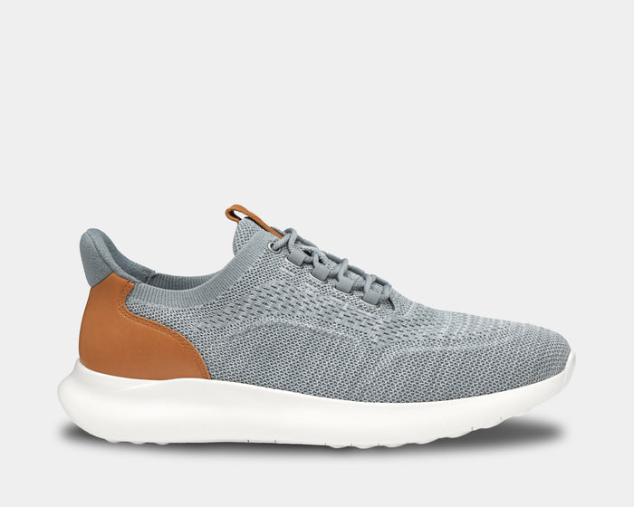 Johnston & Murphy Amherst 2.0 Knit Plain Toe sneakers in light gray knit fabric with tan leather accents and white sole, side view.