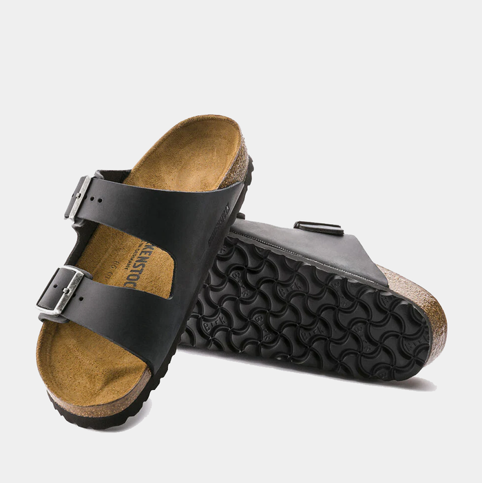 Birkenstock Arizona Oiled Leather sandals in black with dual adjustable buckled straps, cork footbed, and textured rubber outsole.