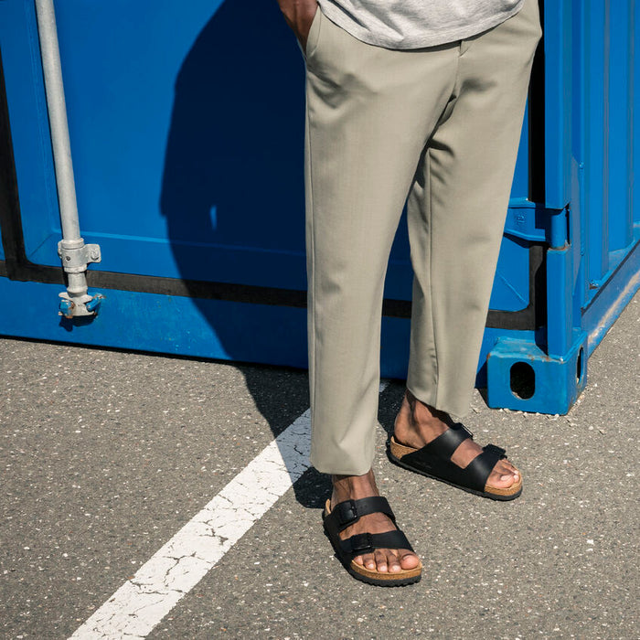 Birkenstock Arizona Soft Footbed Birko-Flor® sandals in black with adjustable straps and cork sole, worn outdoors.