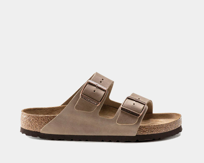 Birkenstock Arizona Soft Footbed Oiled Leather sandals in taupe featuring dual adjustable straps with metal buckles and contoured cork-latex footbed, side view.