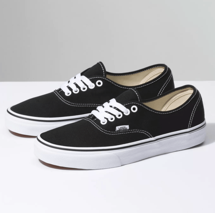 Vans Authentic shoes in black canvas with white laces, contrast stitching, and white rubber sole, side angle view.