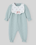 Light blue baby romper with floral bib on a light gray background