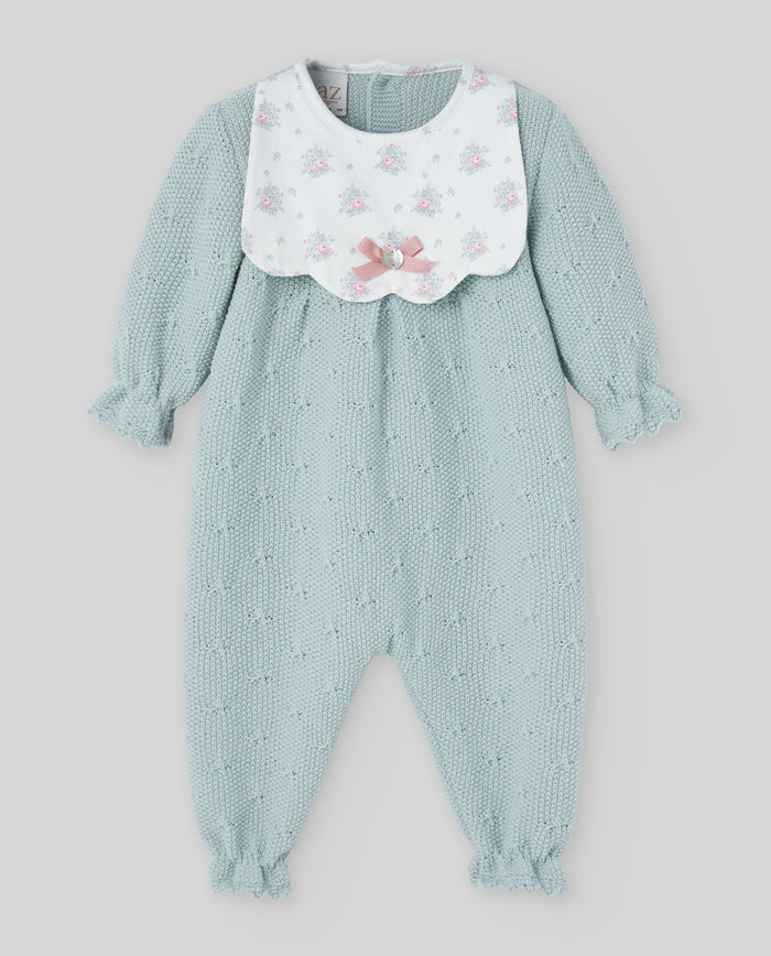 Light blue baby romper with floral bib on a light gray background